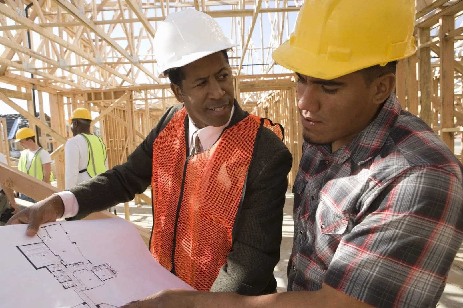Built environment professionals reviewing construction plans on site